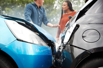 woman and man with car accident in front of them